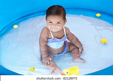 Baby Girl Playing With Ducks In Wading Pool