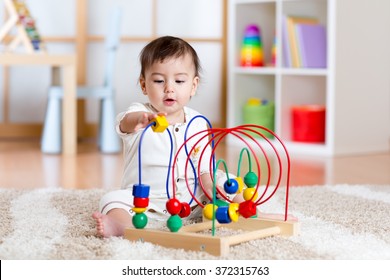 baby girl playing with educational toy in nursery - Shutterstock ID 372315763