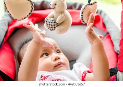 Baby Girl Playing With Mobile In The Cradle