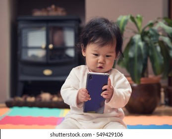 Baby Girl Playing Mobile Phone At Home