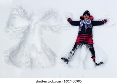 Baby Girl Plays In The Snow Making A Snow Angel