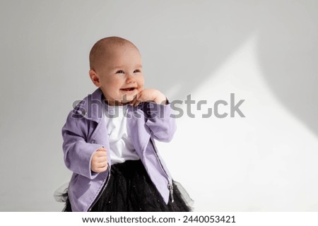 Baby girl posing in a stylish look. Cyclorama, children's portrait.