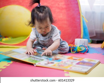 Baby Girl Reading Book At Home