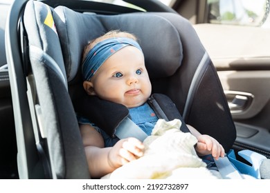 Baby girl sitting in an infant car seat, safety travelling by car with little child. - Shutterstock ID 2192732897