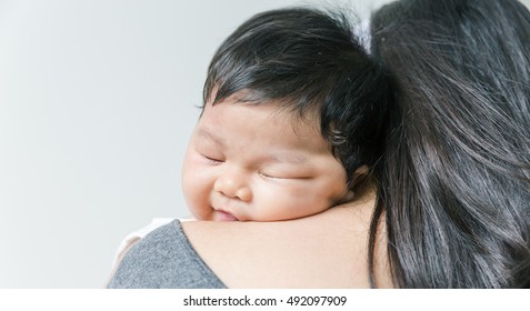 Baby Girl Sleeping On Her Mom Shoulder.