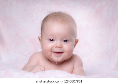 Baby Girl Smiling. Drooling In A Child