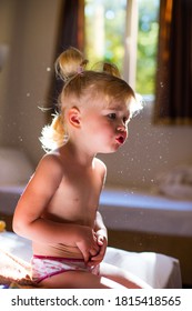 Baby Girl In The Sun Is Sitting Indoors And Playing. Dust Particles Are Visible In The Air