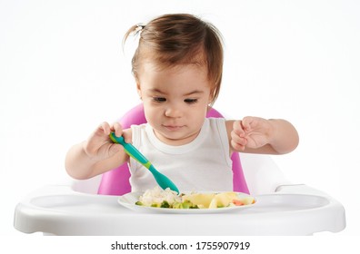 Baby Girl Trying New Food Isolated On White Studio Background