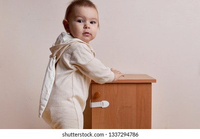 Baby Girl Trying To Open The Cabinet With Baby Proofing Lock Safe Home