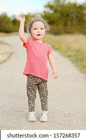 Baby Girl Waving Her Hand Saying Goodbye Outdoors