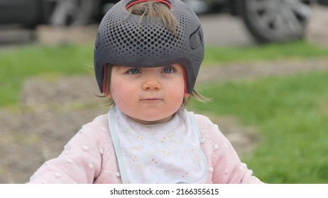 Baby girl wearing a cranial remoulding helmet for flat head - Shutterstock ID 2166355615