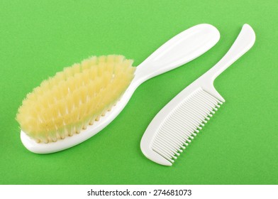 Baby Hair Care Set Of Soft Brush And Comb Isolated On The Green Background