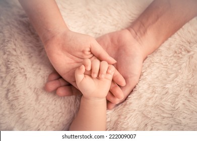Baby hand. Closeup of baby hand into parents hands. Family concept