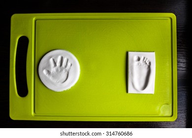 Baby Hand And Foot Print On Green Cutting Board. New Life Concept