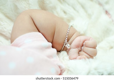 Baby Hand On Bed Wearing Bracelet