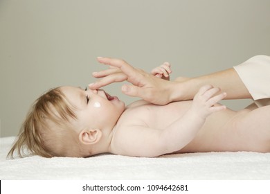 Baby Handling: Woman Applying Moisturizing Cream On Her Baby's Face