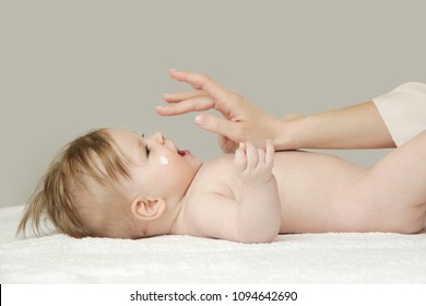 Baby Handling: Woman Applying Moisturizing Cream On Her Baby's Face