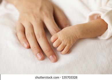 Baby hands and the hands of his mother.
