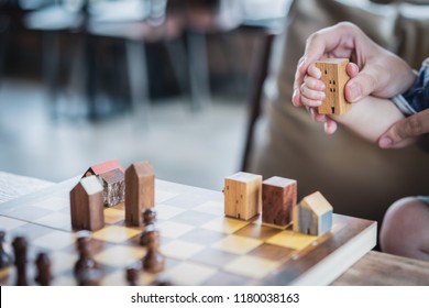 Baby Hands Holding A House Model With Mother Hand. The Concept Of Relocation, Mortgage, Inheritance, Family Assurance Protection And Legacy Planning. 