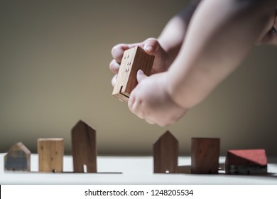 Baby Hands Holding A House Model. The Concept Of Relocation, Mortgage, Inheritance, Family Assurance Protection And Legacy Planning. 