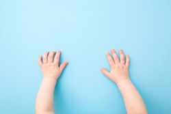Baby Hands On Light Blue Table Background. Pastel Color. Closeup. Point Of View Shot.