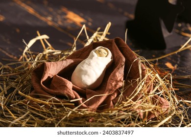 Baby with hay on wooden table. Concept of Christmas story - Powered by Shutterstock