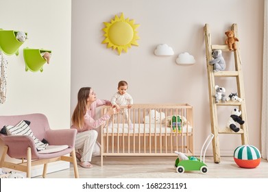 Baby And Her Mom In The Room, Decorative Interior Style With Wooden Cribbed Pink Chair Toy And Stair Decor.