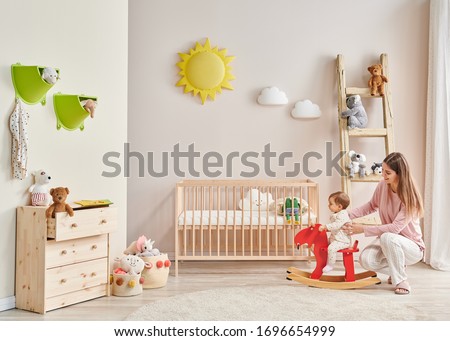 Baby and her mom in the room, decorative interior style with wooden cribbed pink chair toy and stair decor.