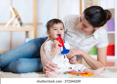 baby and her mother play musical toys