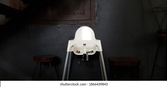 Baby High Chair Sitting Alone In A Dark Corner Of A Restaurant