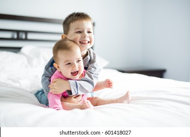 baby and his brother on bed - Shutterstock ID 601418027