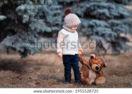 Baby and his friend bear in the park. Winnie the Pooh. Spring walk of a child with a toy. Childhood. Based on a fairy tale.
