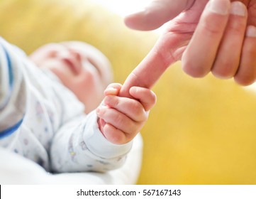 Baby Holding Dad's Finger. Close-up