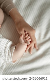 baby holding mother's finger, cute motherhood, New mom and newborn baby hands close up