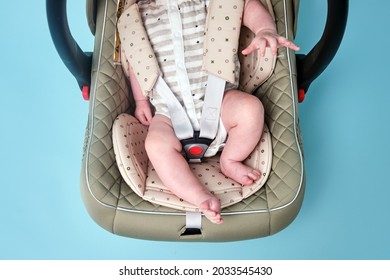 Baby In Infant Car Seat On Blue Studio Background. Carrier For Transporting Newborn Babies In A Chair