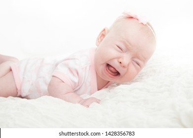 Baby Infant Girl Crying On Stomach While Doing Tummy Time.