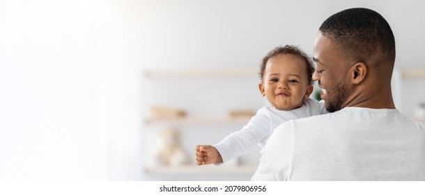Baby Insurance. Young Black Father Holding Cute Smiling Infant Child On Hands At Home, Adorable Little African American Kid Smiling At Camera, Enjoying Time With His Daddy, Panorama With Copy Space - Shutterstock ID 2079806956