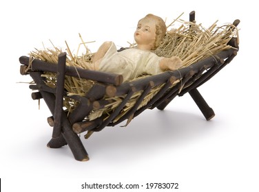 Baby Jesus figurine lying in manger on hay on white background. Clipping path incl.
