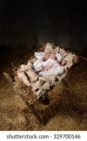 Baby Jesus On A Manger Inside Old Dark Stable