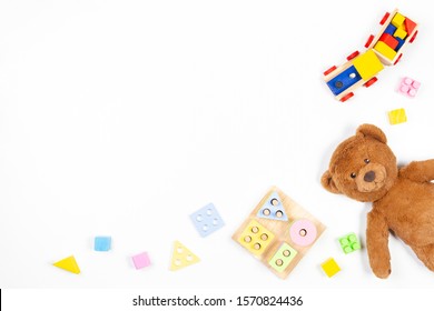 Baby Kids Toys Background. Wooden Educational Geometric Stacking Blocks Shape Color Recognition Puzzle Toy, Wooden Train, Teddy Bear And Colorful Blocks On White Background. Top View, Flat Lay