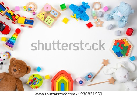 Baby kids toys frame. Set of colorful educational wooden and fluffy toys on white background. Top view, flat lay, copy space for text
