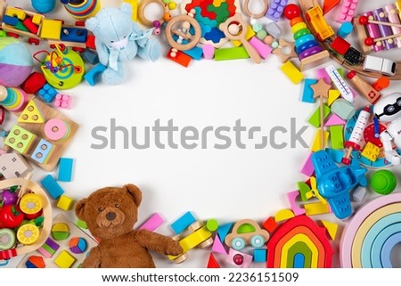 Baby kids toys frame. Set of colorful educational wooden, plastic and fluffy toys on white background. Top view, flat lay