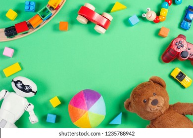 Baby kids toys frame with teddy bear, toy cars, robot, colorful bricks, cubes on pink background