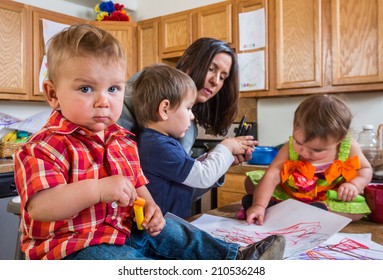 Baby In Kitchen With Guilty Face Looks At Camera