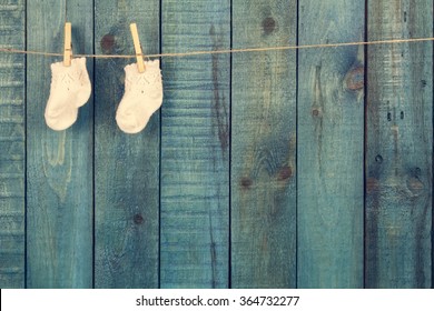 baby knitted woolen socks on turquoise wooden background