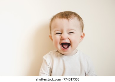 Baby laughing isolated on white. happy child with flu and running nose