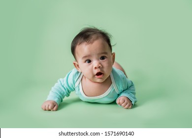 baby laying on her belly. tummy time cute baby in studio portrait