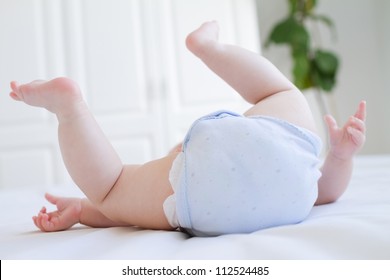 Baby Legs And Bottom In Diaper And Blue Body Suit