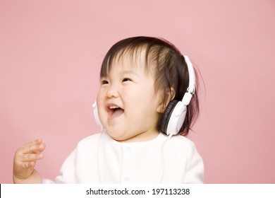 Baby Listening To Music With A Headphone