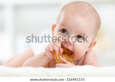 baby little child lying on bed weared diaper with teether